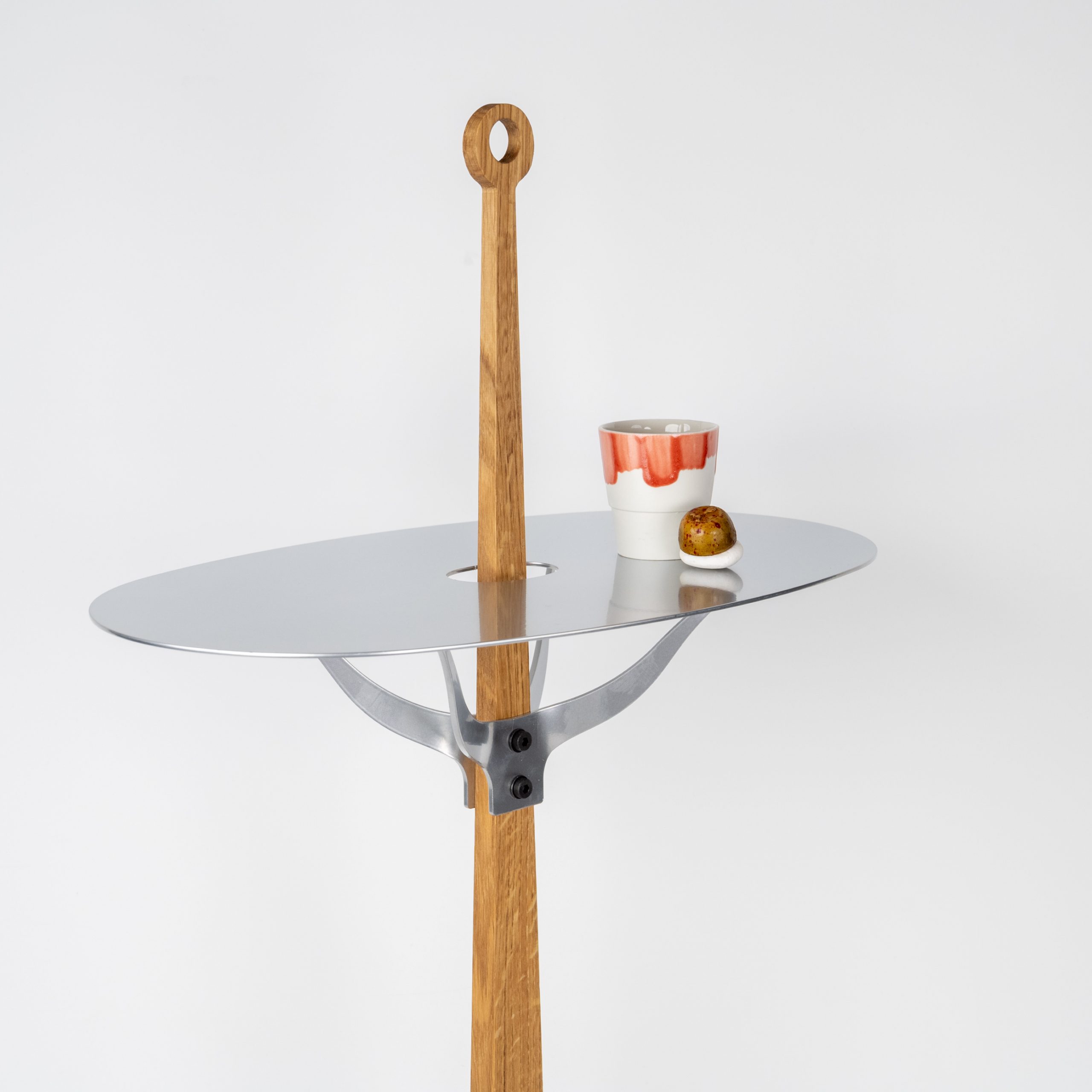 Detail van The Ore Sidetable met op het silvercoat blad een espressokopje en bonbon