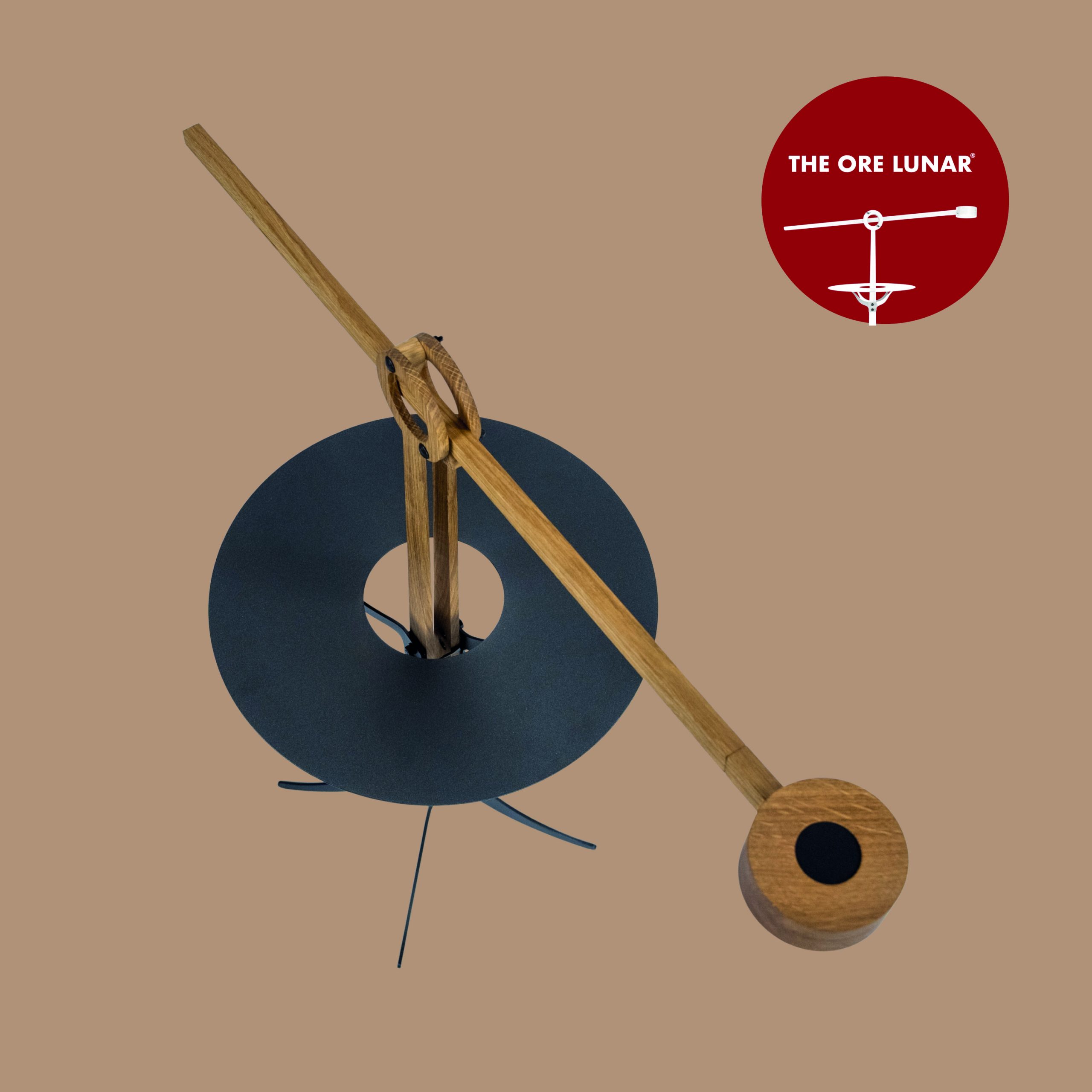 The Ore Lunar van bovenaf gezien, arm met lamp is uitgeschoven. Het blad en de voet zijn zwart gecoat metaal en de houder en arm met lapmp zijn van eikenhout gemaakt.